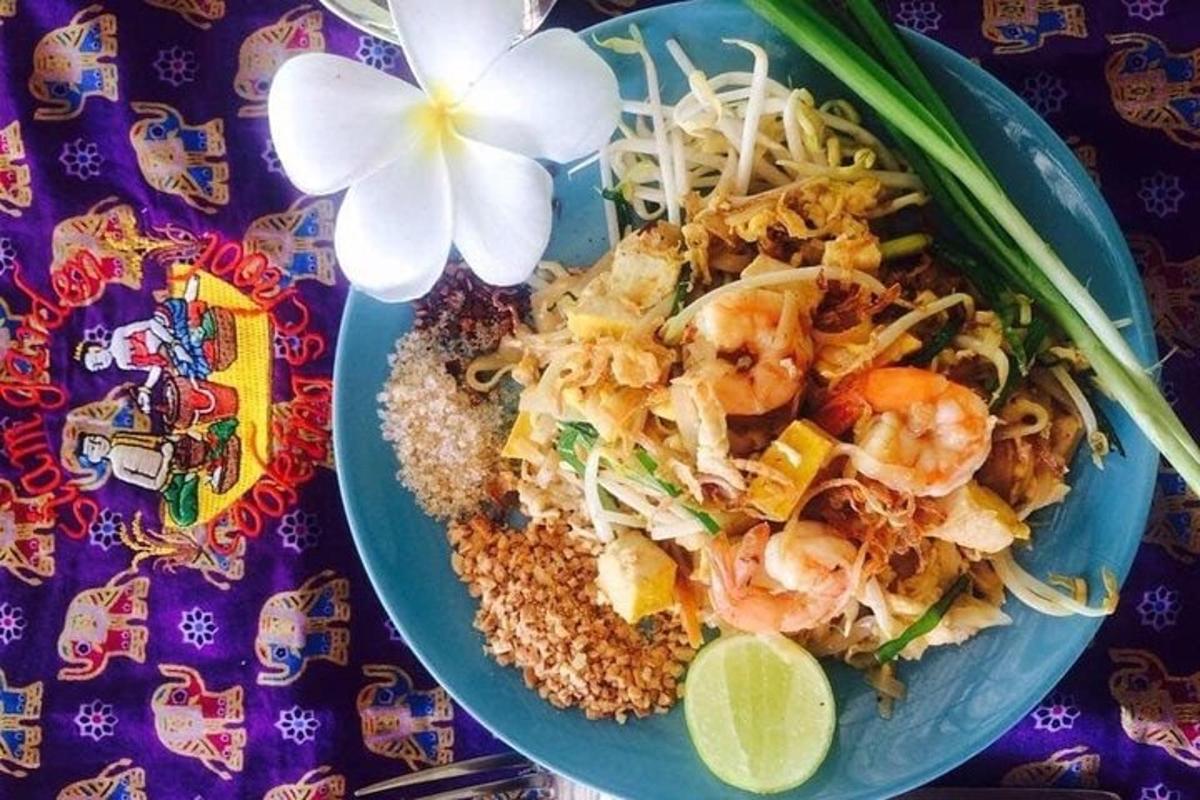 a plate of food with shrimp and rice and a flower