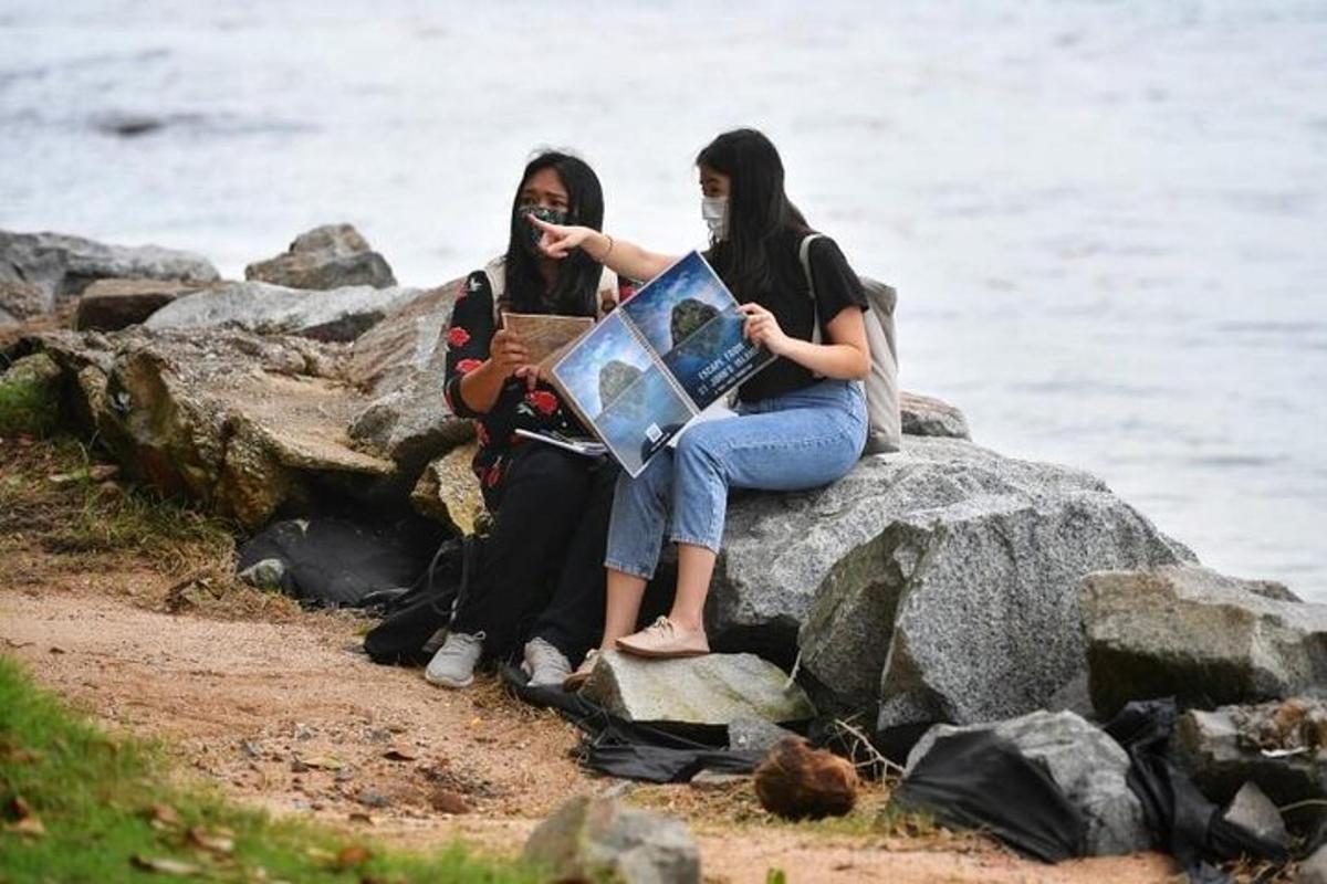 dve ženski, ki sedita na skali in gledata zemljevid