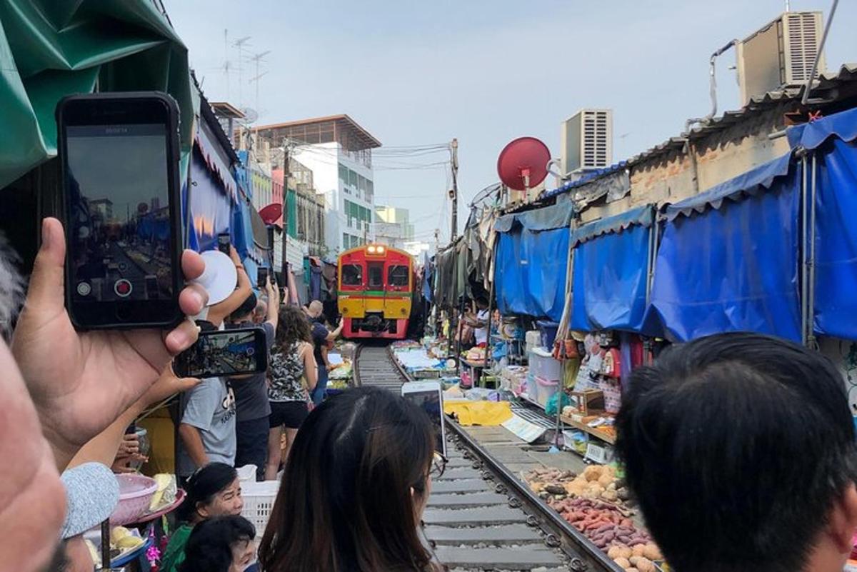 o persoană care fotografiază un tren într-o piață
