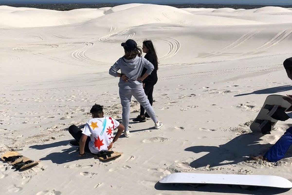 eine Gruppe von Menschen steht auf dem Sand in der Wüste