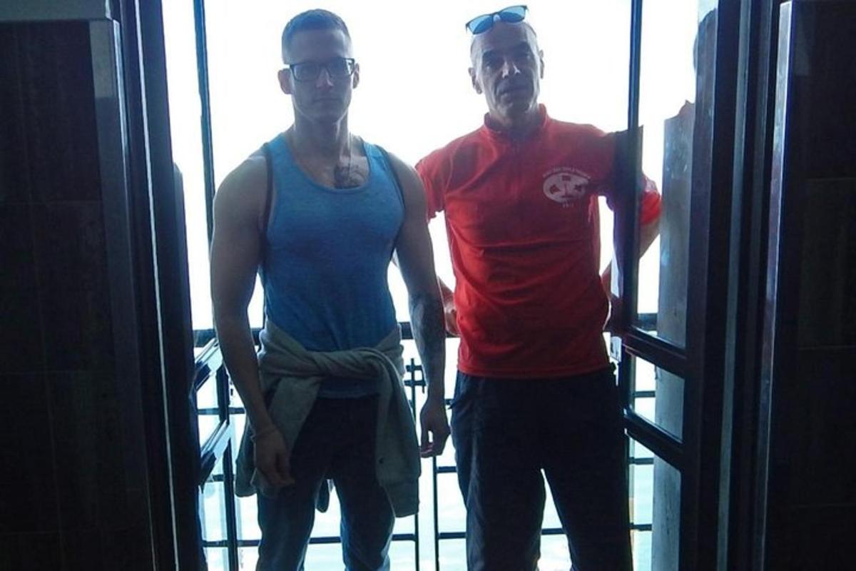 Dos hombres de pie frente a una ventana