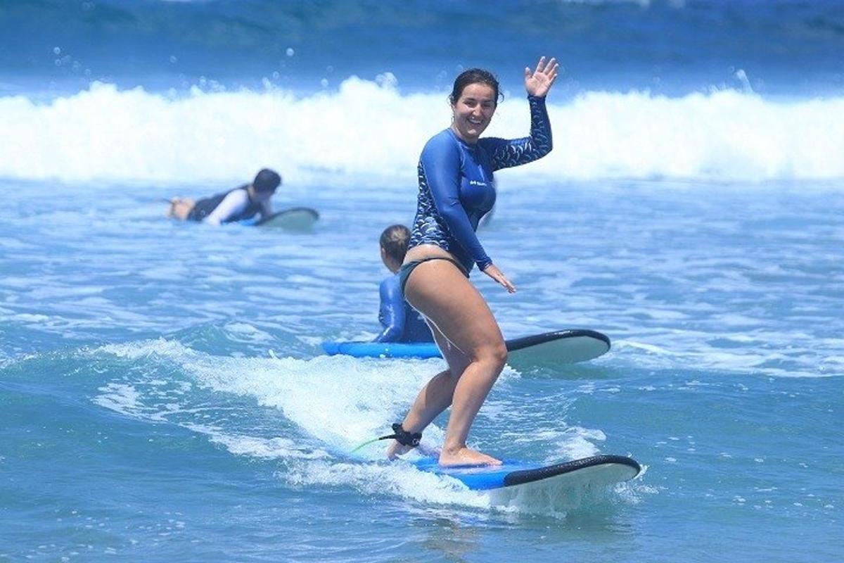 žena jedoucí na vlně na surfovém prkně v oceánu
