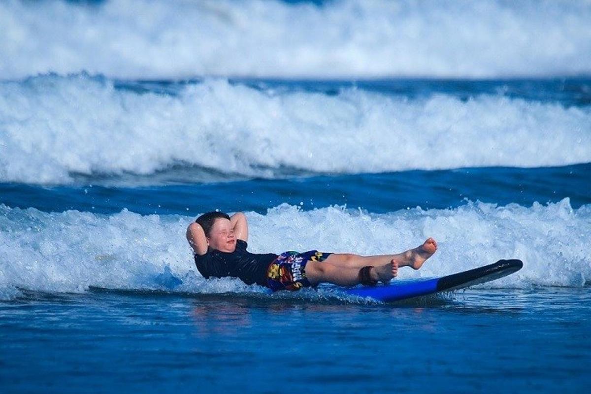 žena ležící na surfovém prkně v oceánu