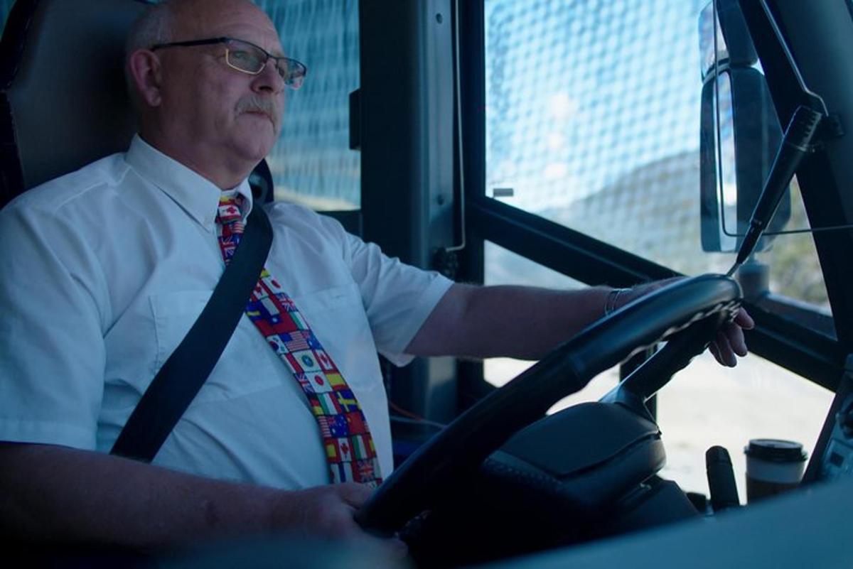 muž v kravatě řídící autobus