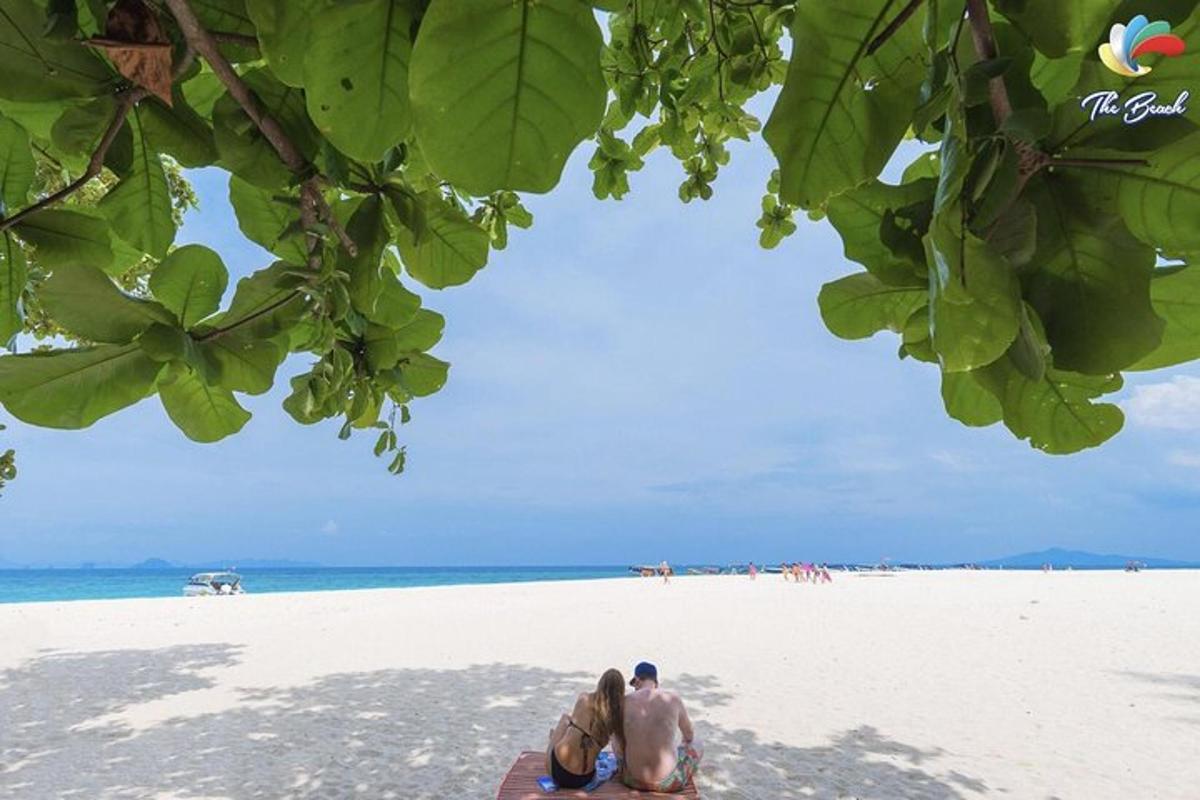 a shirtless man sitting on the beach