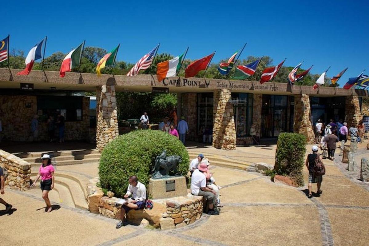 a group of people sitting in front of a building with flags