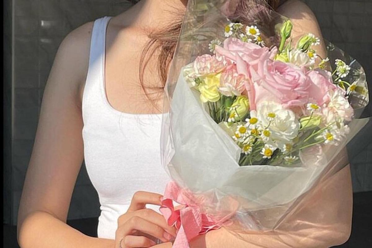 seorang wanita memegang sejambak bunga