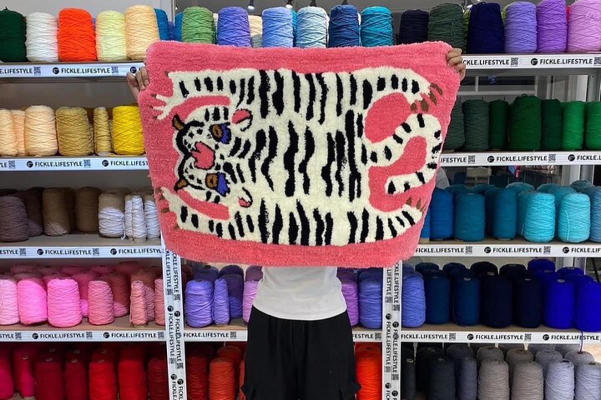 una persona tiene in mano un tappeto con una tigre sopra
