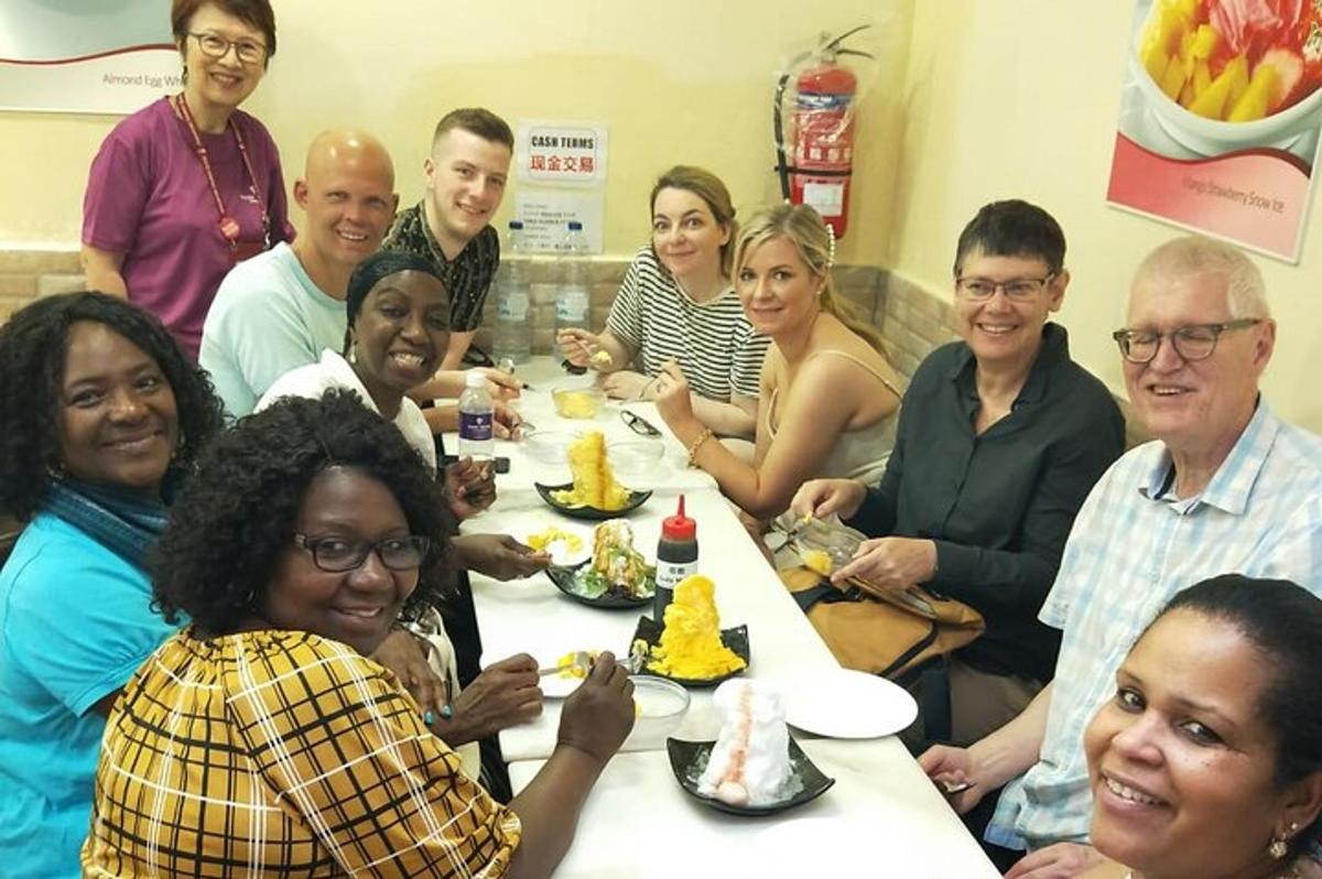um grupo de pessoas sentadas ao redor de uma mesa comendo bolo