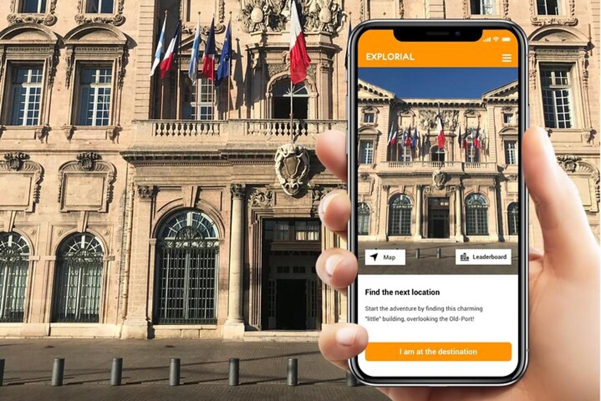 a person holding up a cell phone in front of a building
