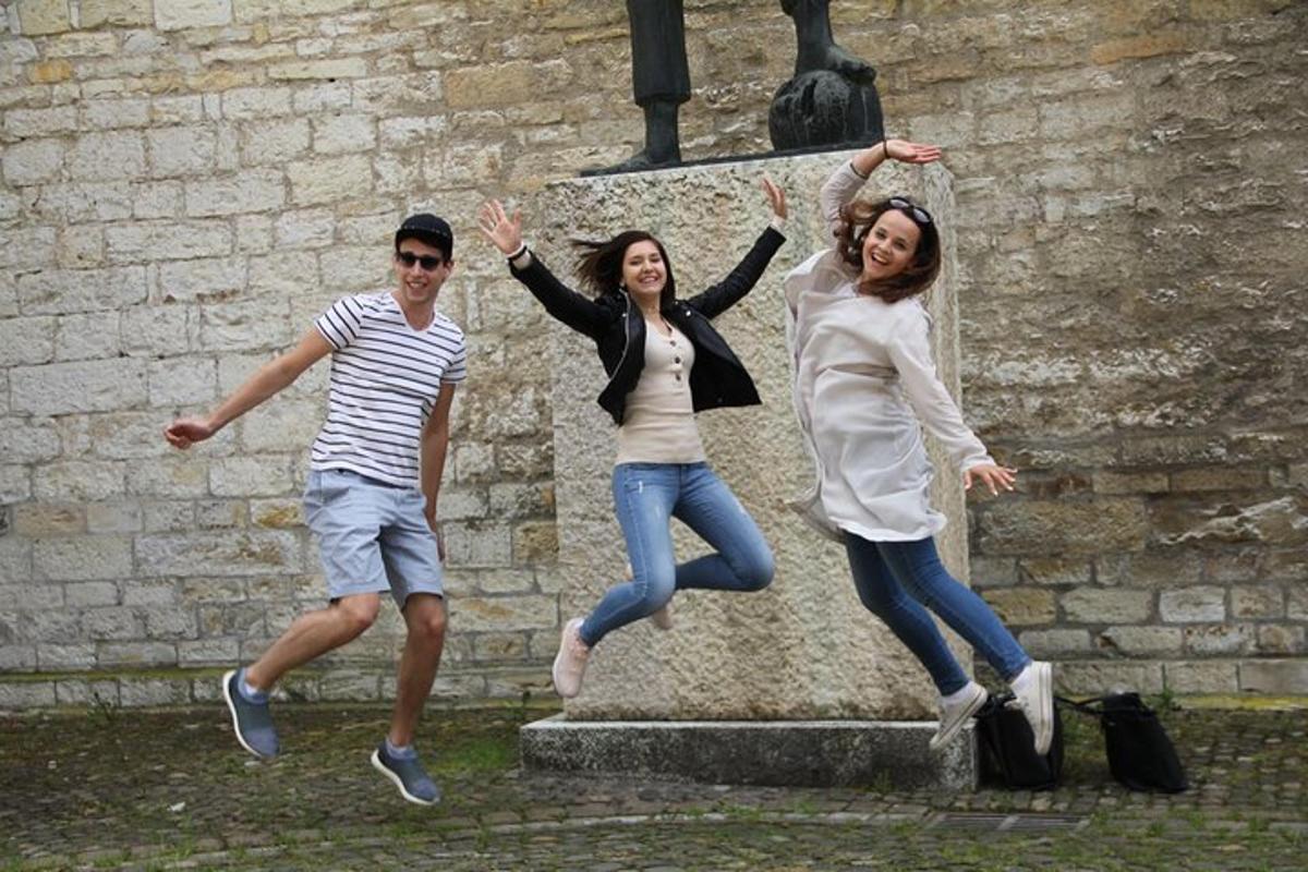 a group of three people jumping in front of a statue