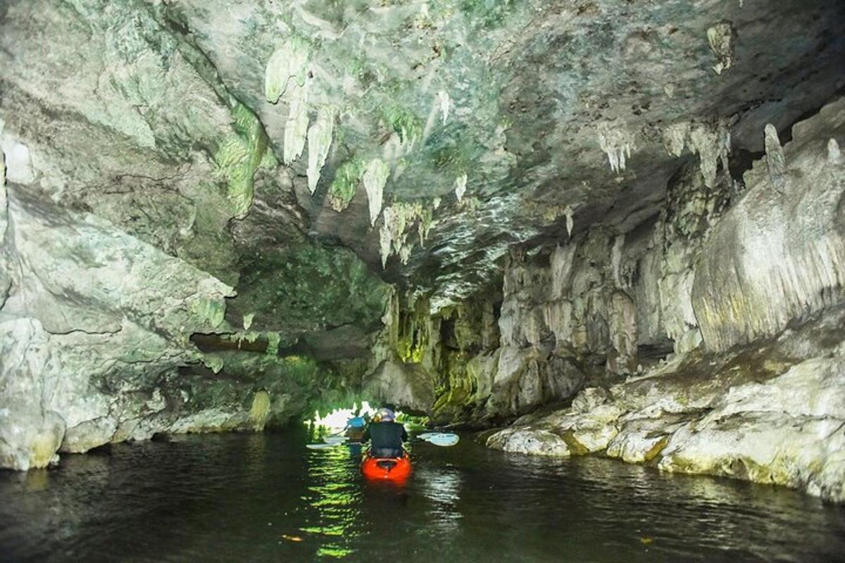 um barco vermelho em um rio em uma caverna