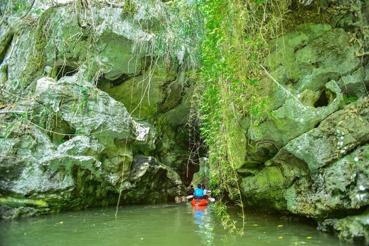 una persona in kayak in un fiume vicino a una grotta