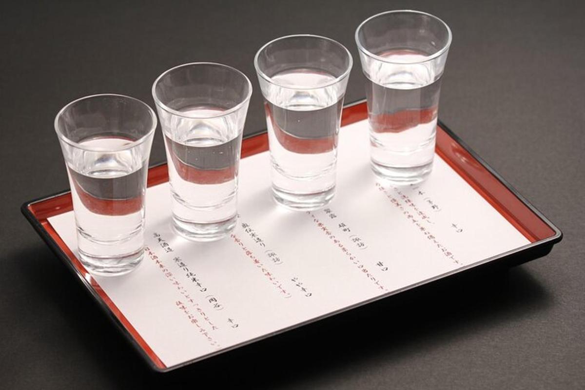 Una bandeja con cuatro vasos de agua sobre un papel.