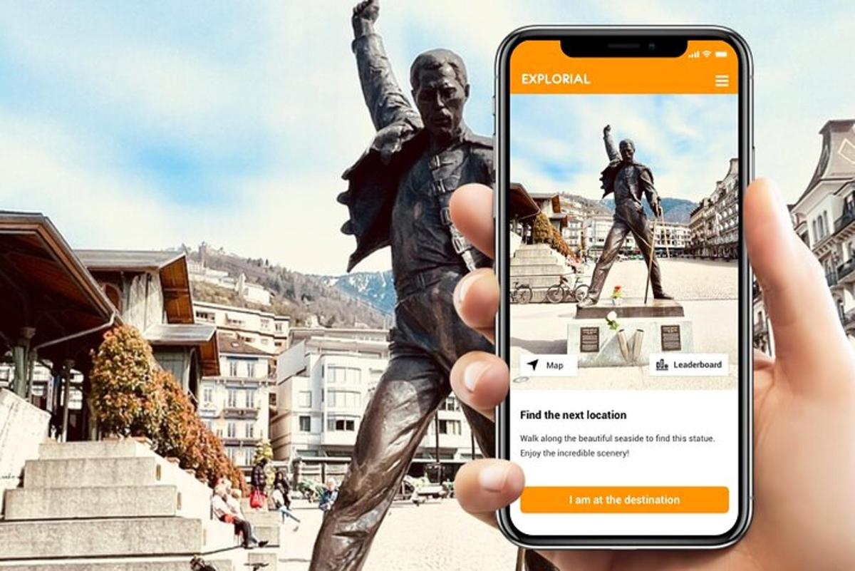 osoba držící telefon před sochou