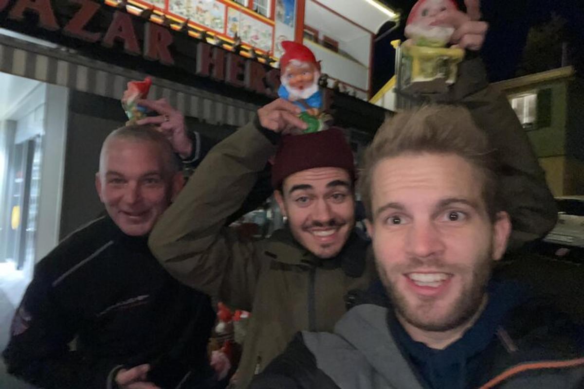 a group of three men holding up toy dolls