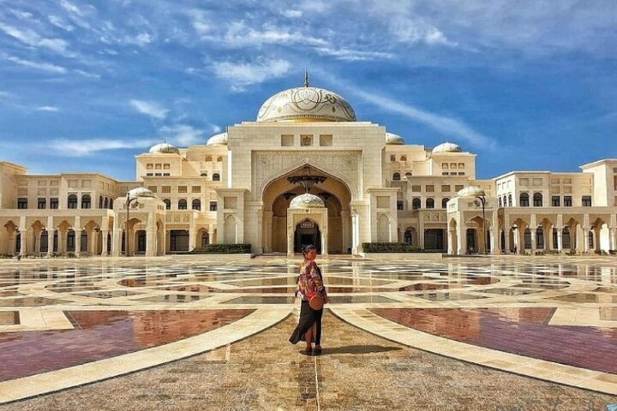 une femme debout devant un grand bâtiment