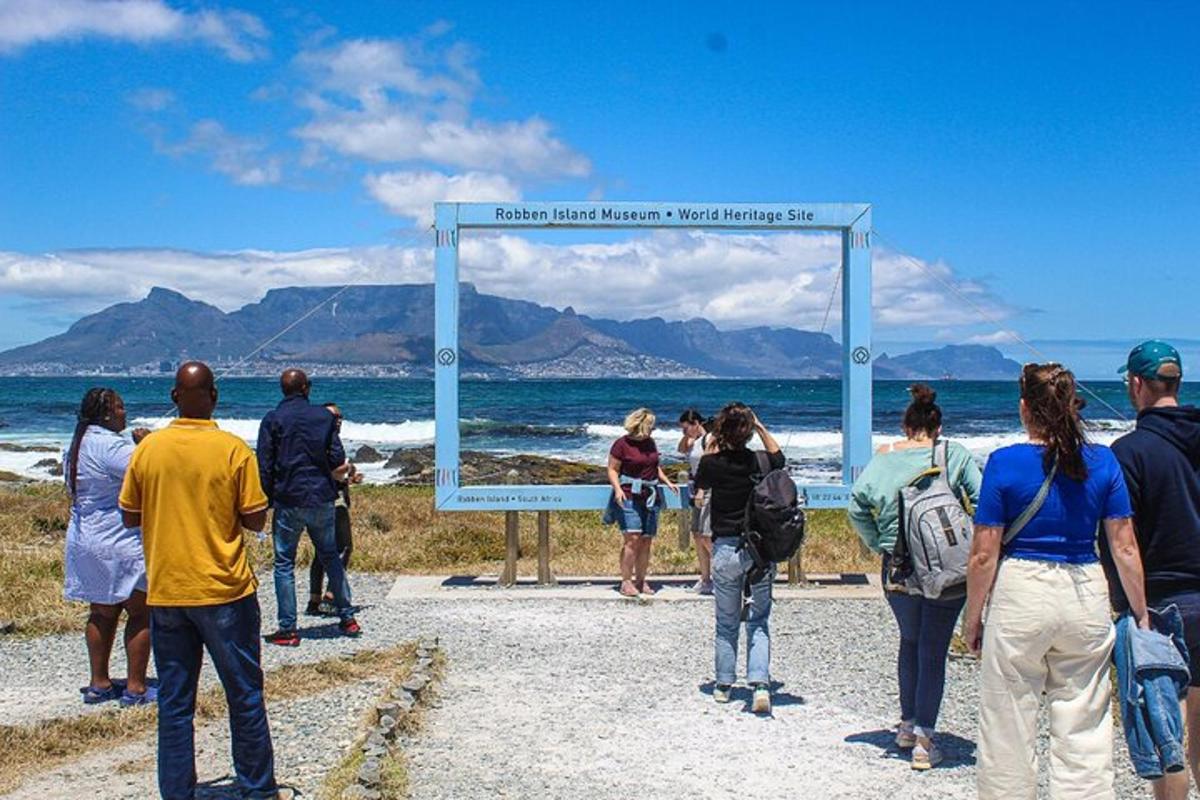 un gruppo di persone in piedi attorno a un cartello sulla spiaggia