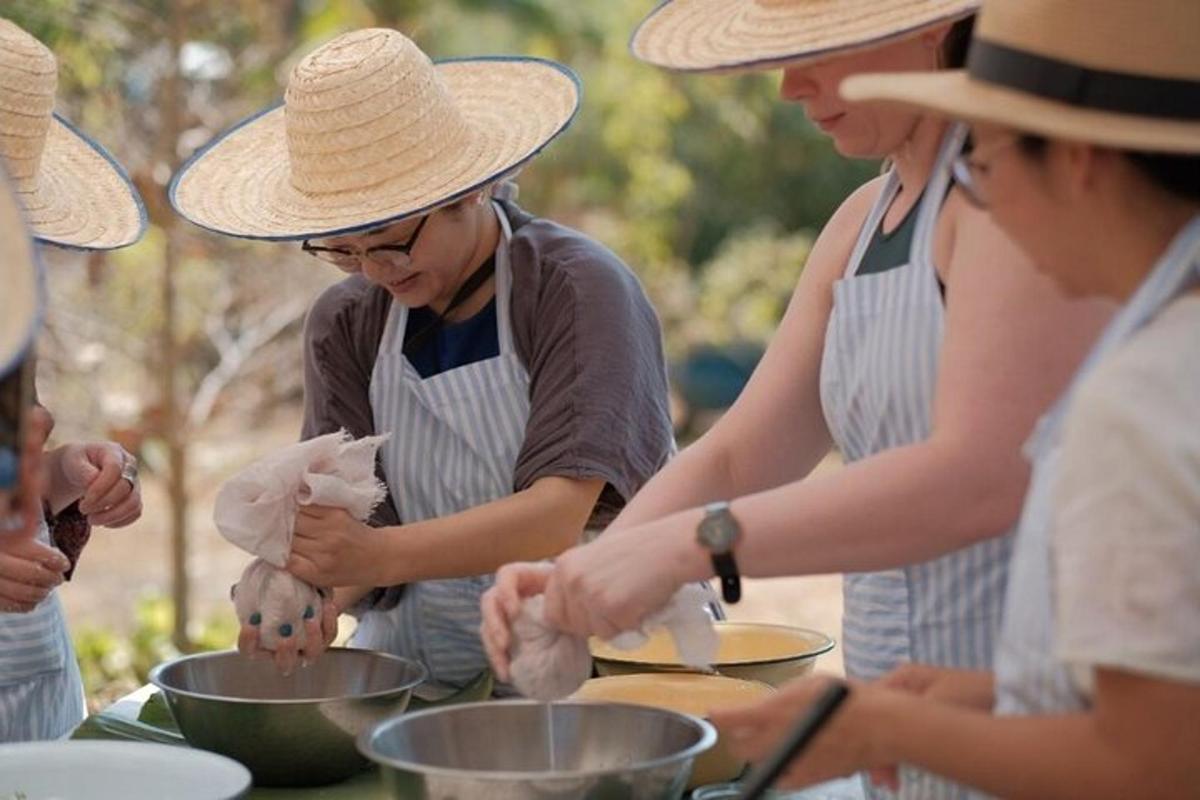 sekumpulan wanita dalam apron menyediakan makanan dalam baldi