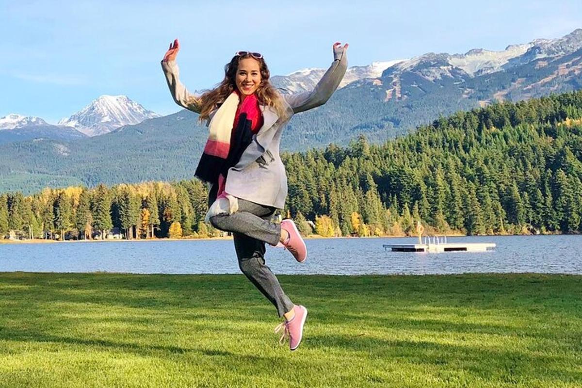 una donna che salta in aria davanti a un lago