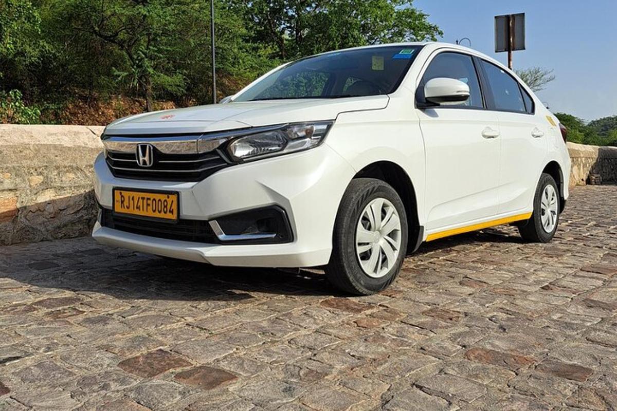a white car is parked on a stone driveway
