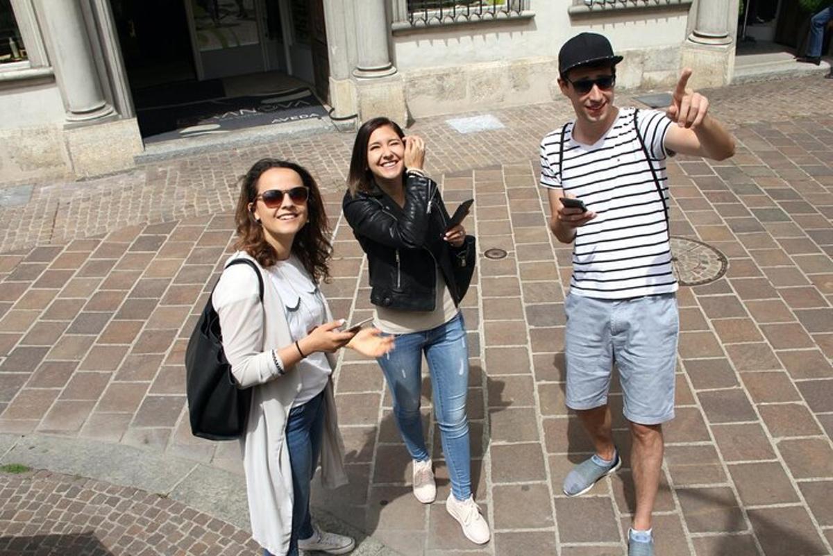 две жене и мушкарац позирају за фотографију са својим мобилним телефонима