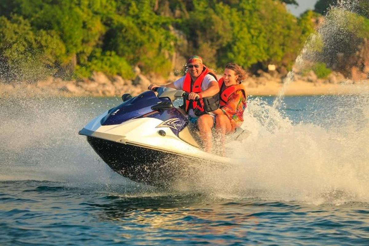 moški in ženska, ki se vozita na vodnem skuterju v vodi