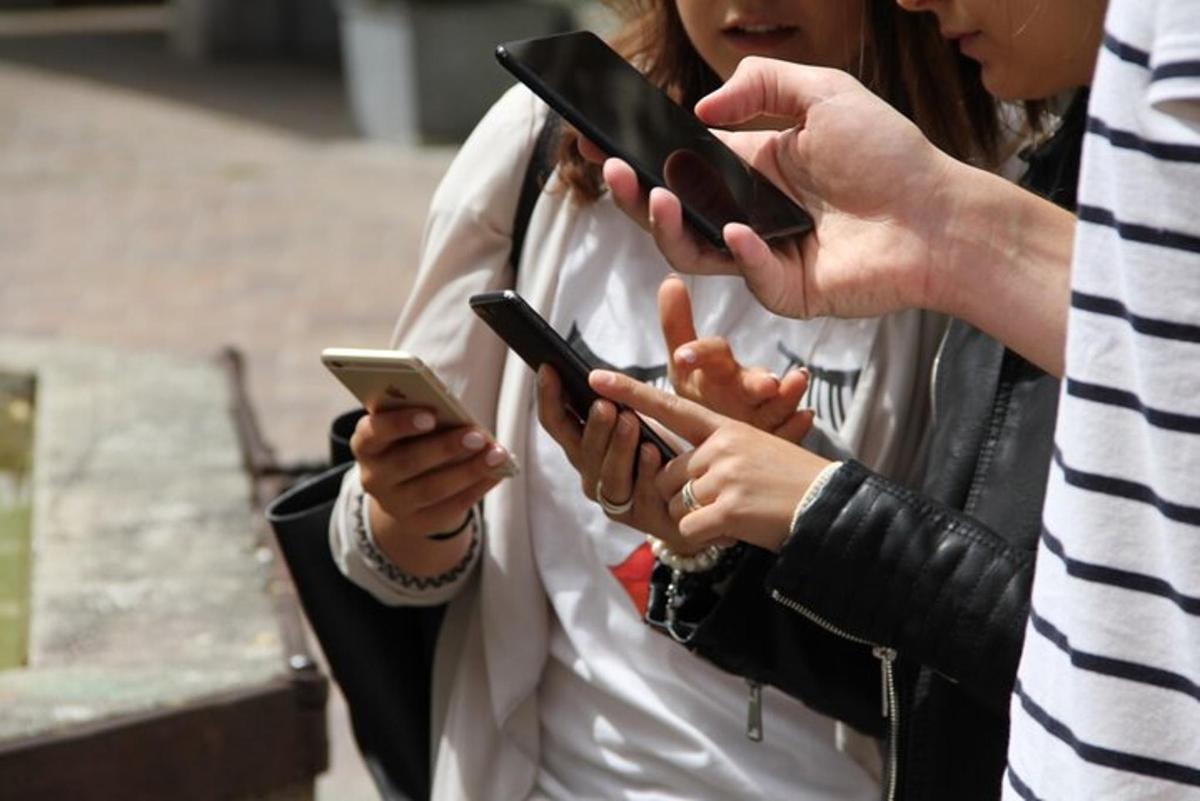 skupina lidí, kteří se dívají do svých mobilních telefonů