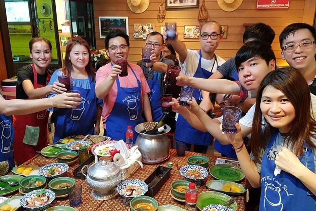 a group of people standing around a table with food