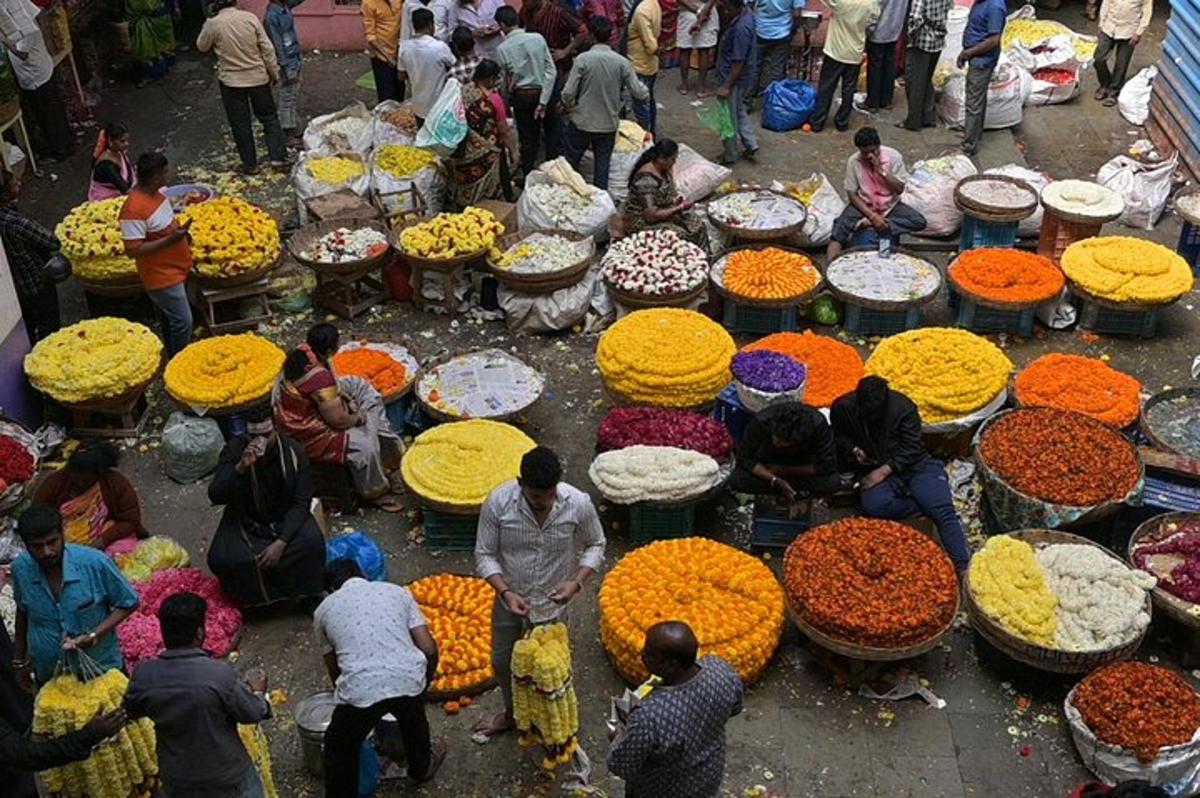 a group of people standing around a market with flowers