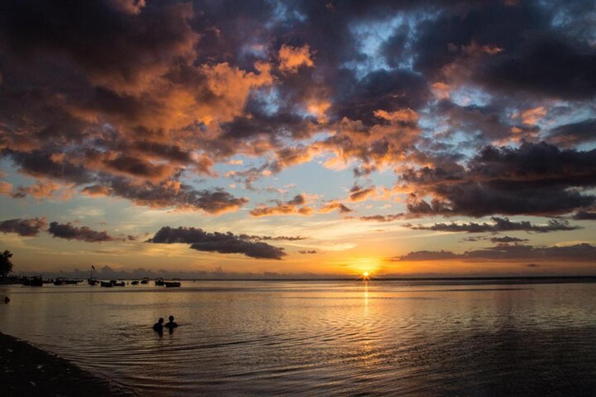 due persone sono in piedi nell'acqua al tramonto