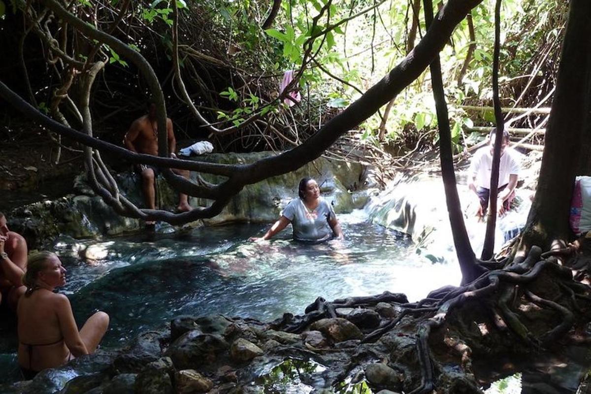 sekumpulan orang yang duduk di dalam kolam air di sungai