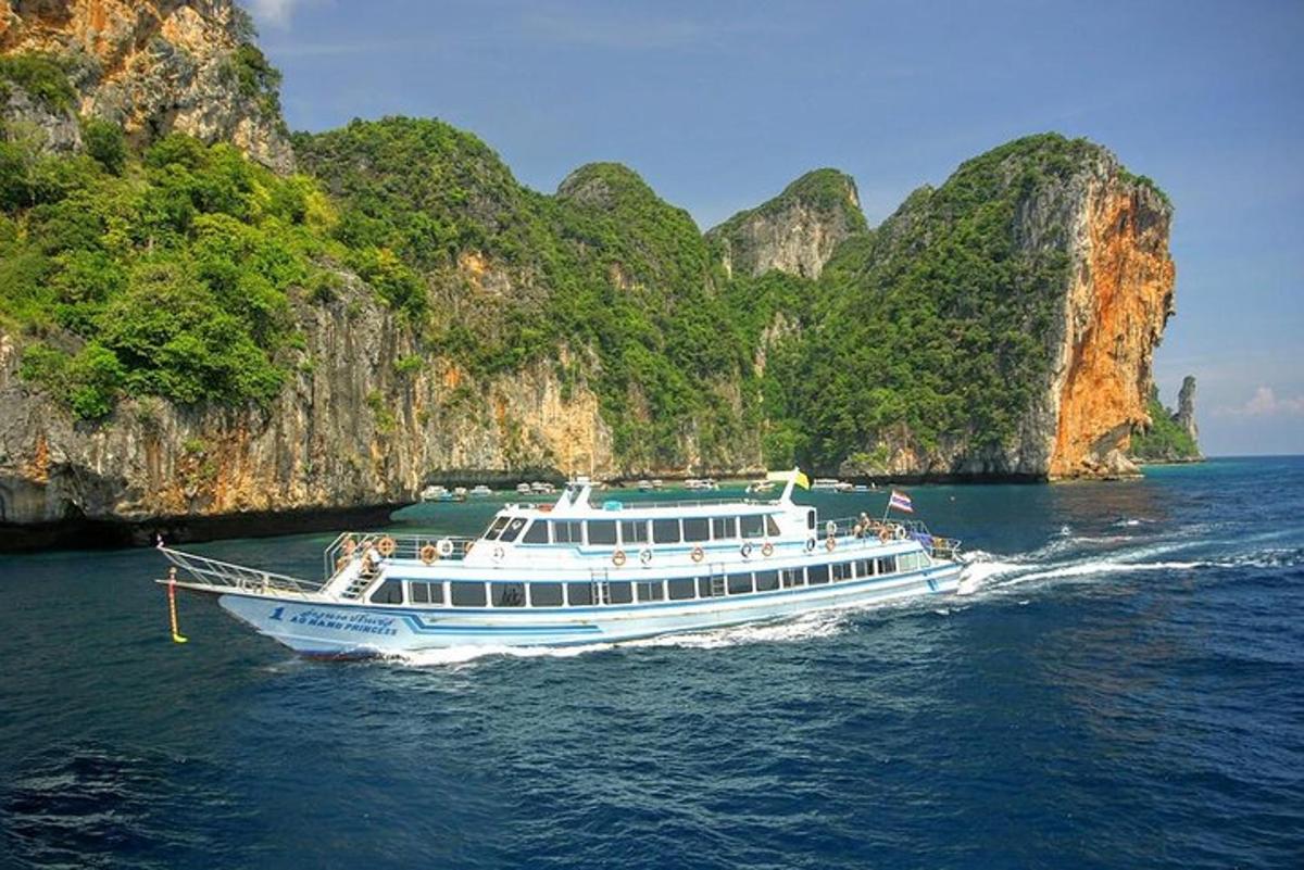 ein weißes Boot im Wasser in der Nähe einiger Klippen