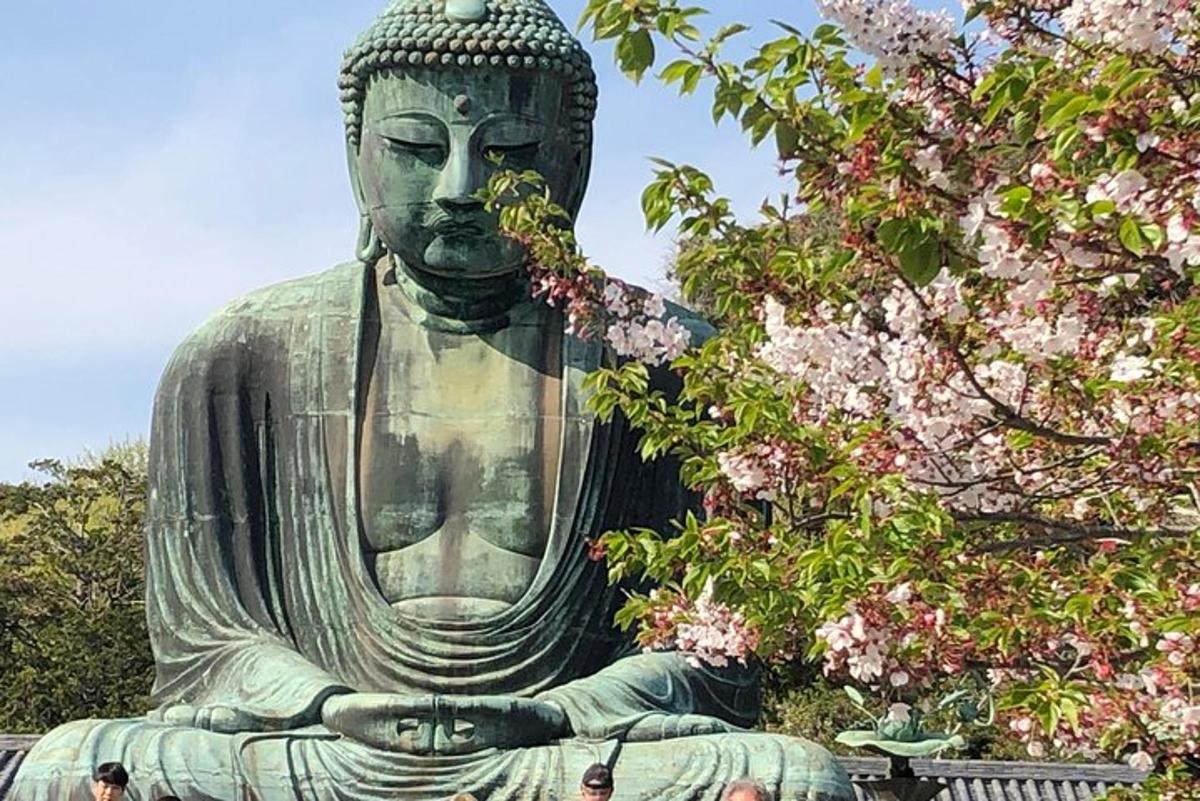 una gran estàtua de Buda en plena agitació davant d'un arbre