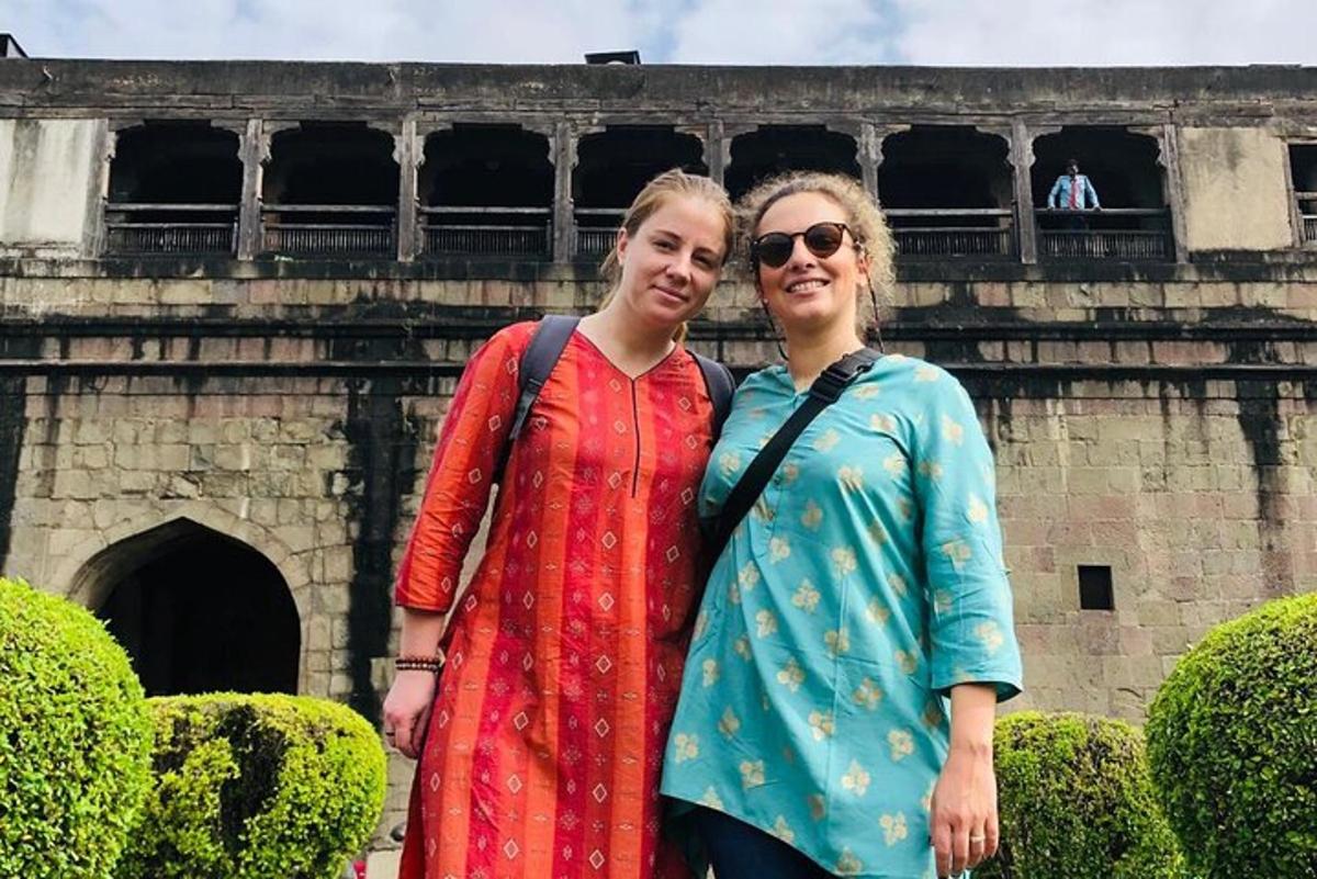 two women are standing in front of a building
