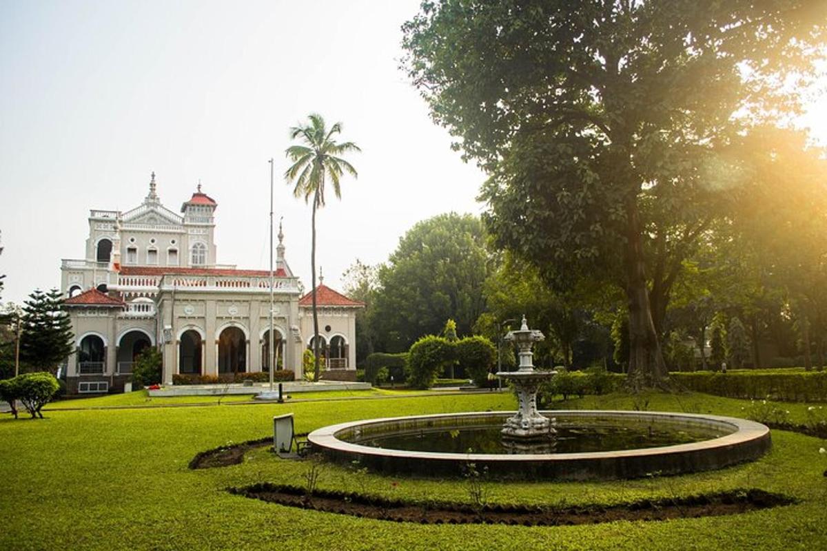 a large building with a fountain in the middle of a park