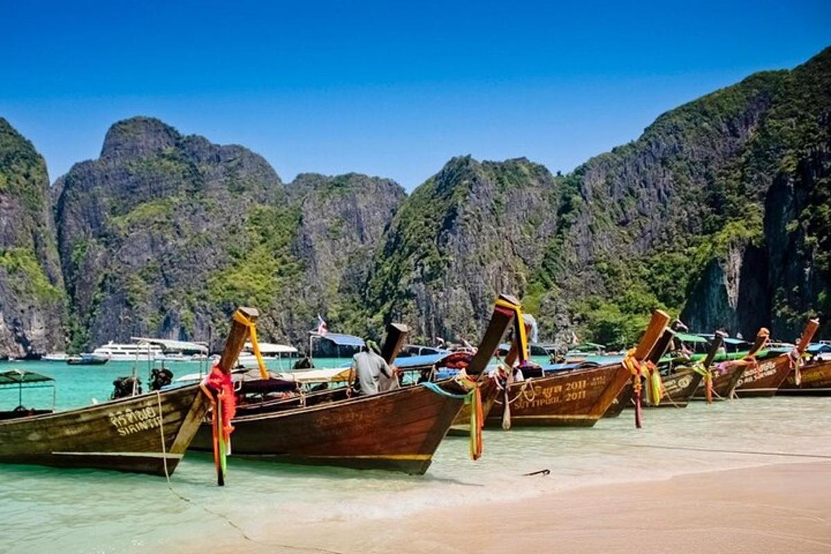 a row of boats sitting on the beach in the water