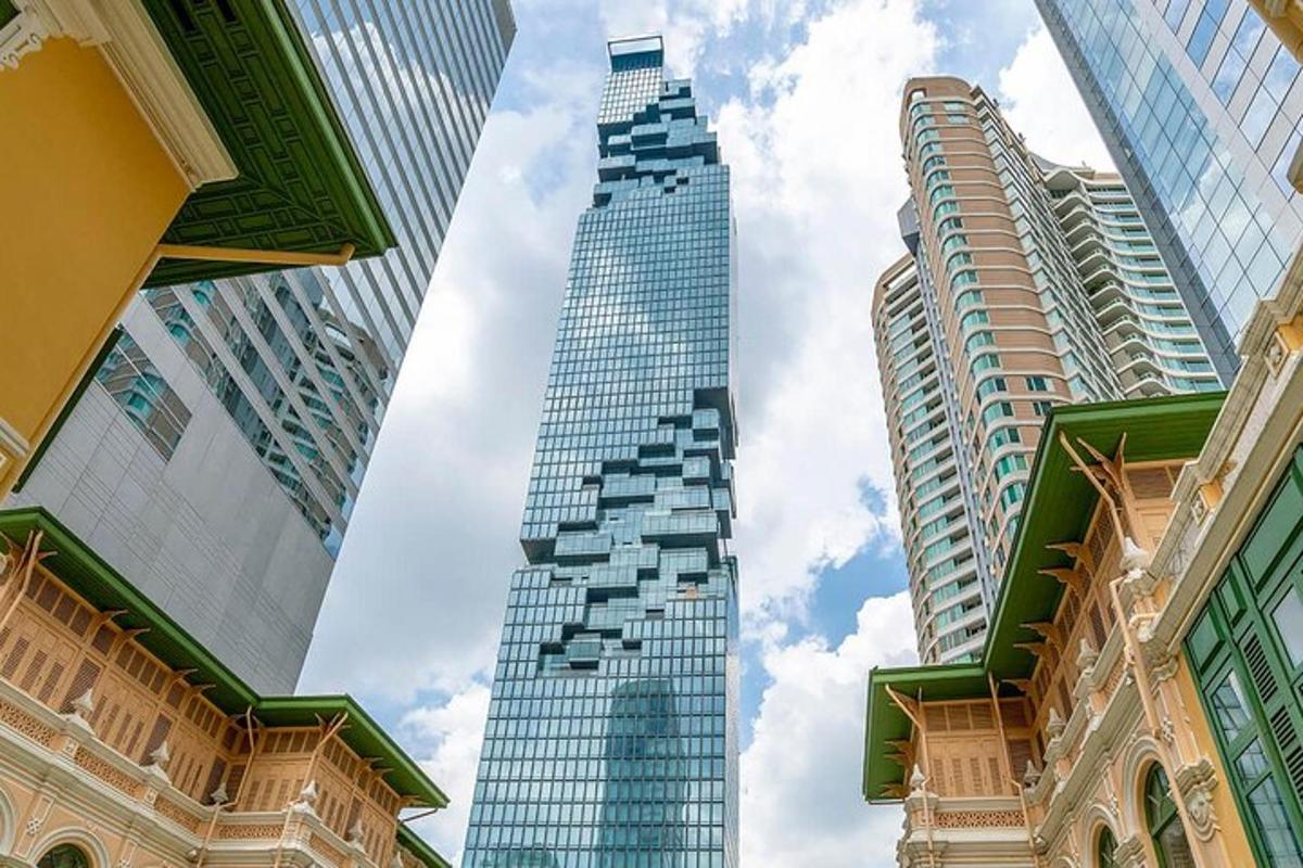 ein hohes Glasgebäude in einer Stadt mit hohen Gebäuden