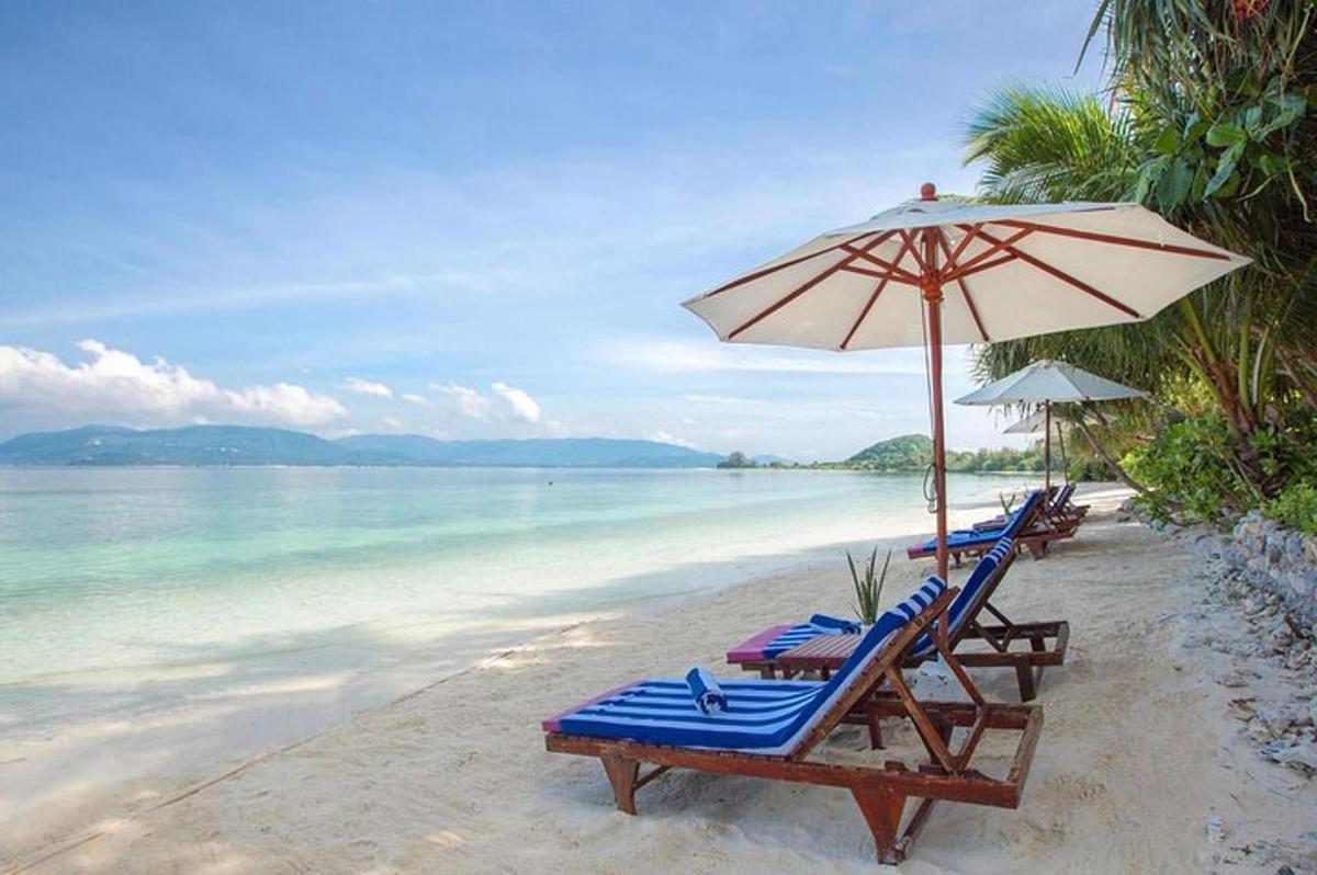 dua kerusi santai dan payung di pantai