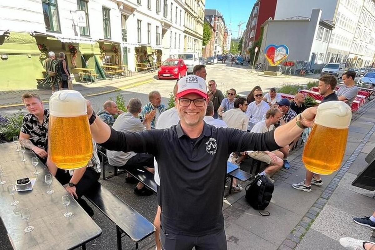 un home que sosté dos grans gots de cervesa