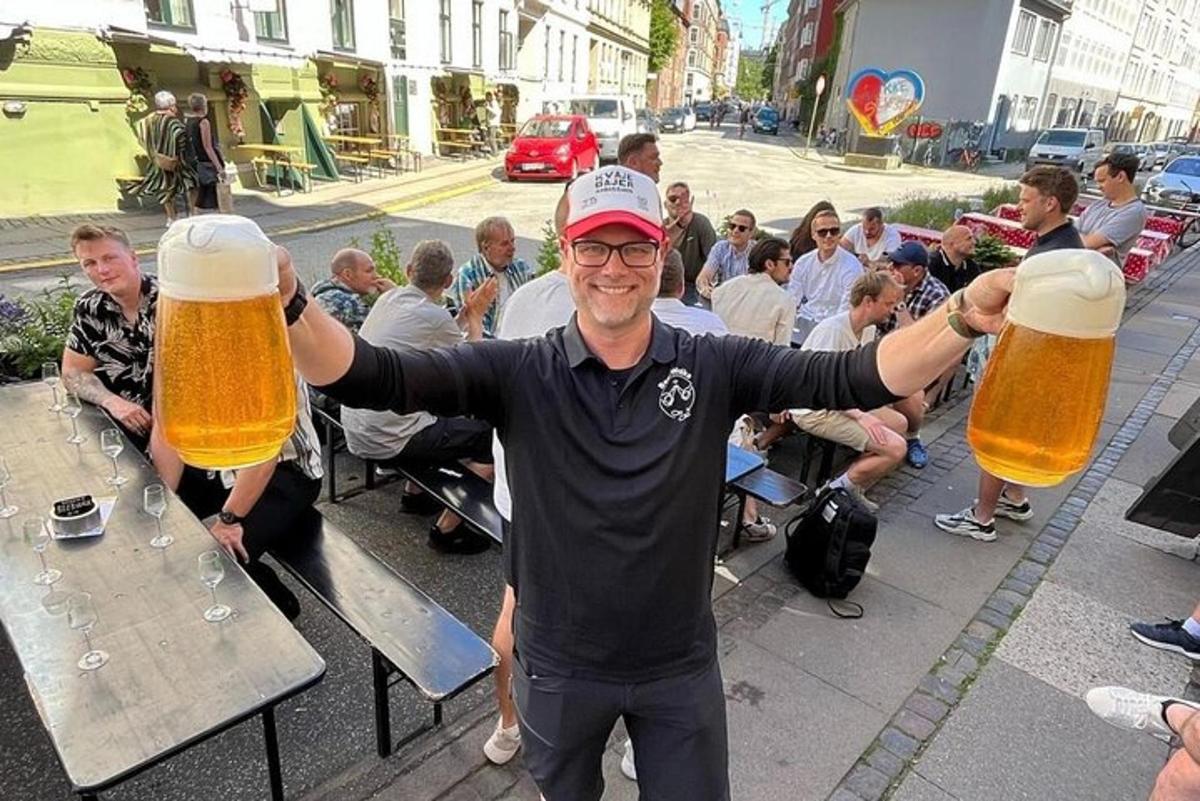 a man holding two large glasses of beer