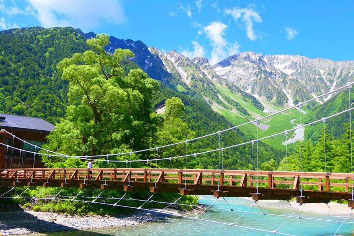 un ponte sopra un fiume con le montagne sullo sfondo