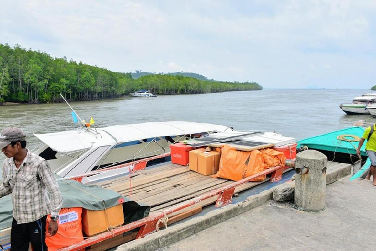 a man standing next to a boat at a dock