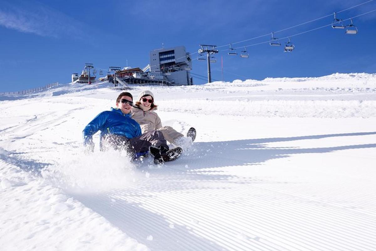 két ember snowboardozik lefelé egy hófödte lejtőn