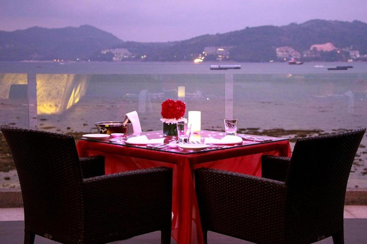 rdeča miza s stoli in miza s pogledom na ocean