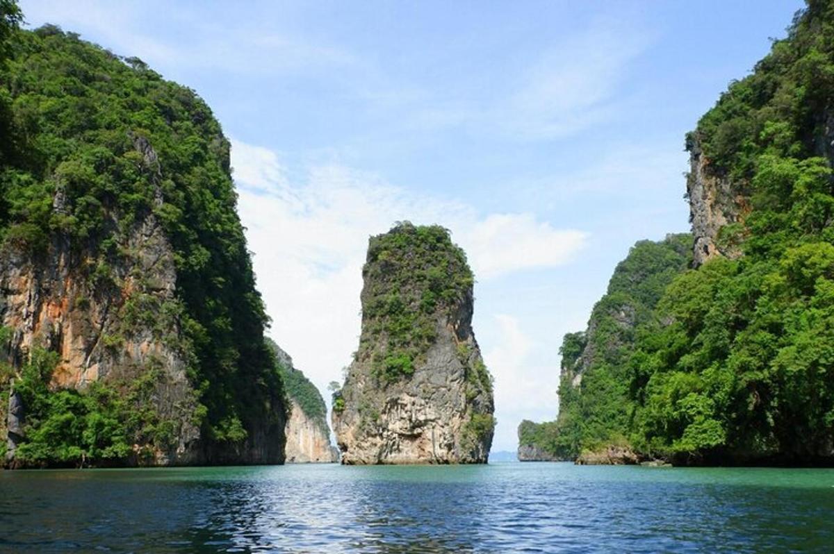 a boat in the water between two limestone cliffs