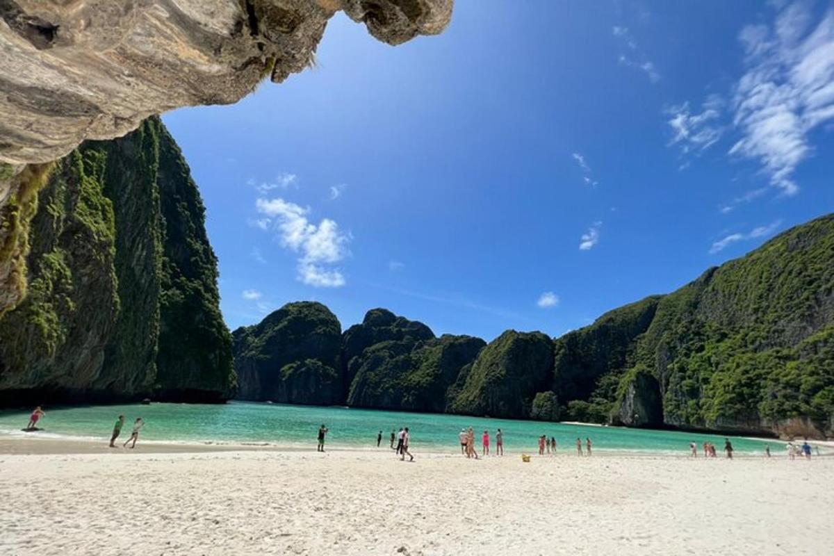 un gruppo di persone su una spiaggia vicino a una montagna