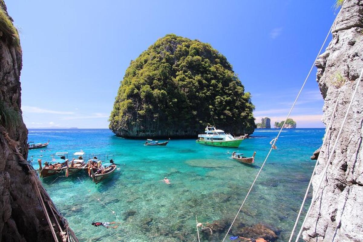 un gruppo di barche in acqua vicino a una piccola isola