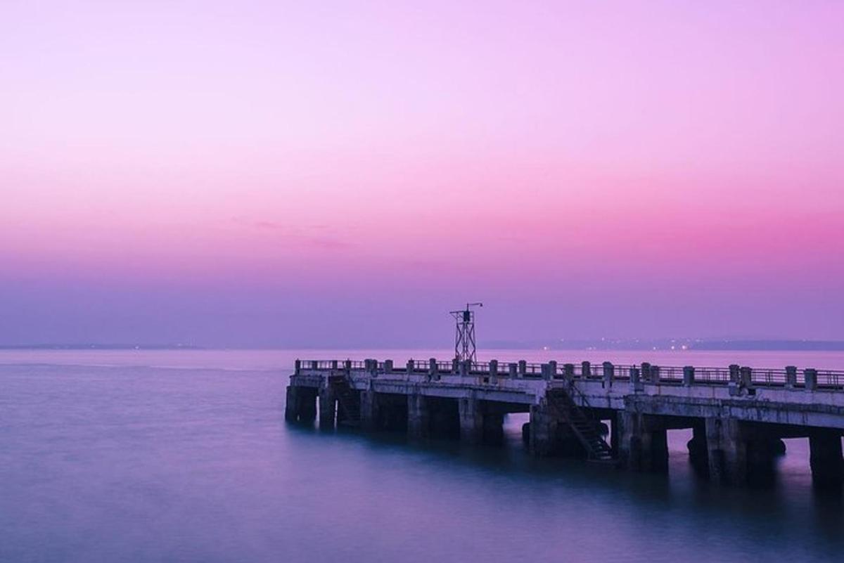 un moll a l'aigua amb un cel rosa i morat