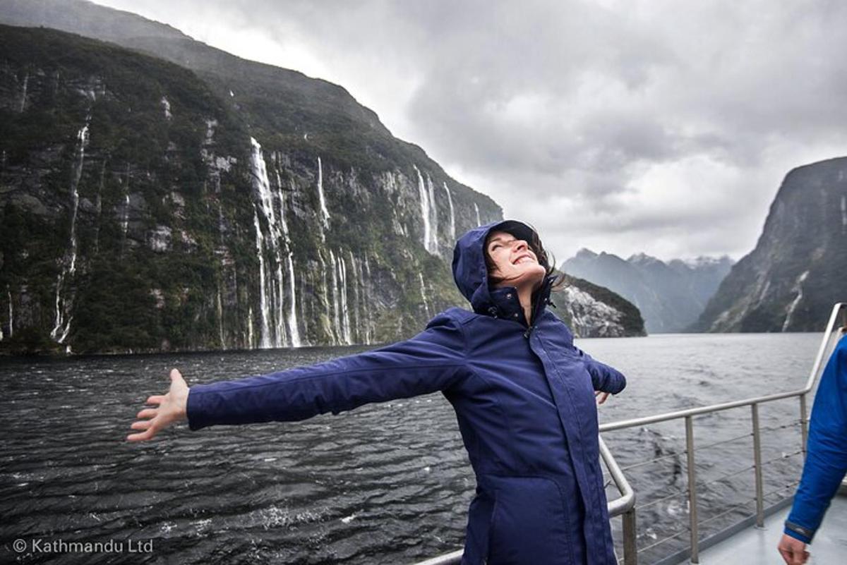 eine Frau auf einem Boot vor einem Wasserfall